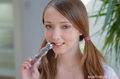 Busty buffy holding dildo to her lips pigtails framing her pretty face