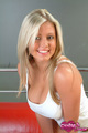 Blonde leaning forward in white top showing cleavage