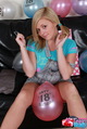 Tegan brady seated with balloon between her legs blonde hair in pigtails