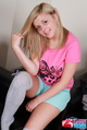 Playing with her blonde hair wering pink top