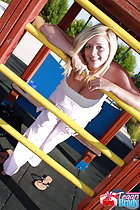 Leaning against bars in playground exposing her cleavage
