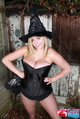 Hands on hips wearing witch hat in black lingerie